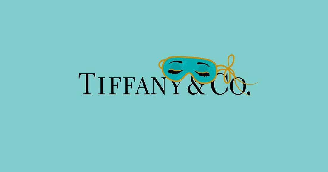 Tiffany & Co. logo featuring a decorative mask on a turquoise background.