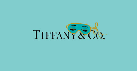 Tiffany & Co. logo featuring a decorative mask on a turquoise background.