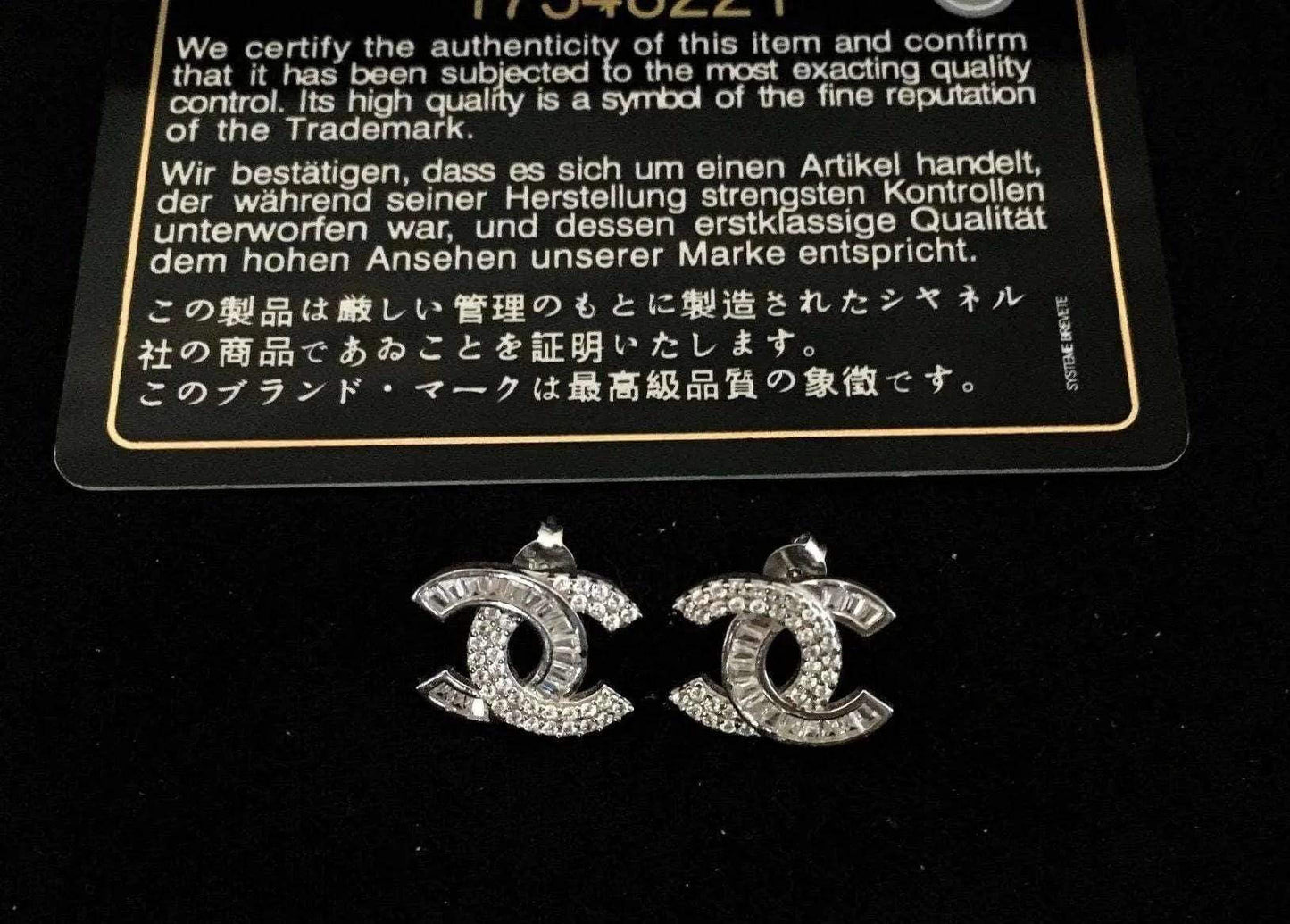 Authentic Chanel stud earrings with 925 sterling silver and baguette white zircon stones on black background