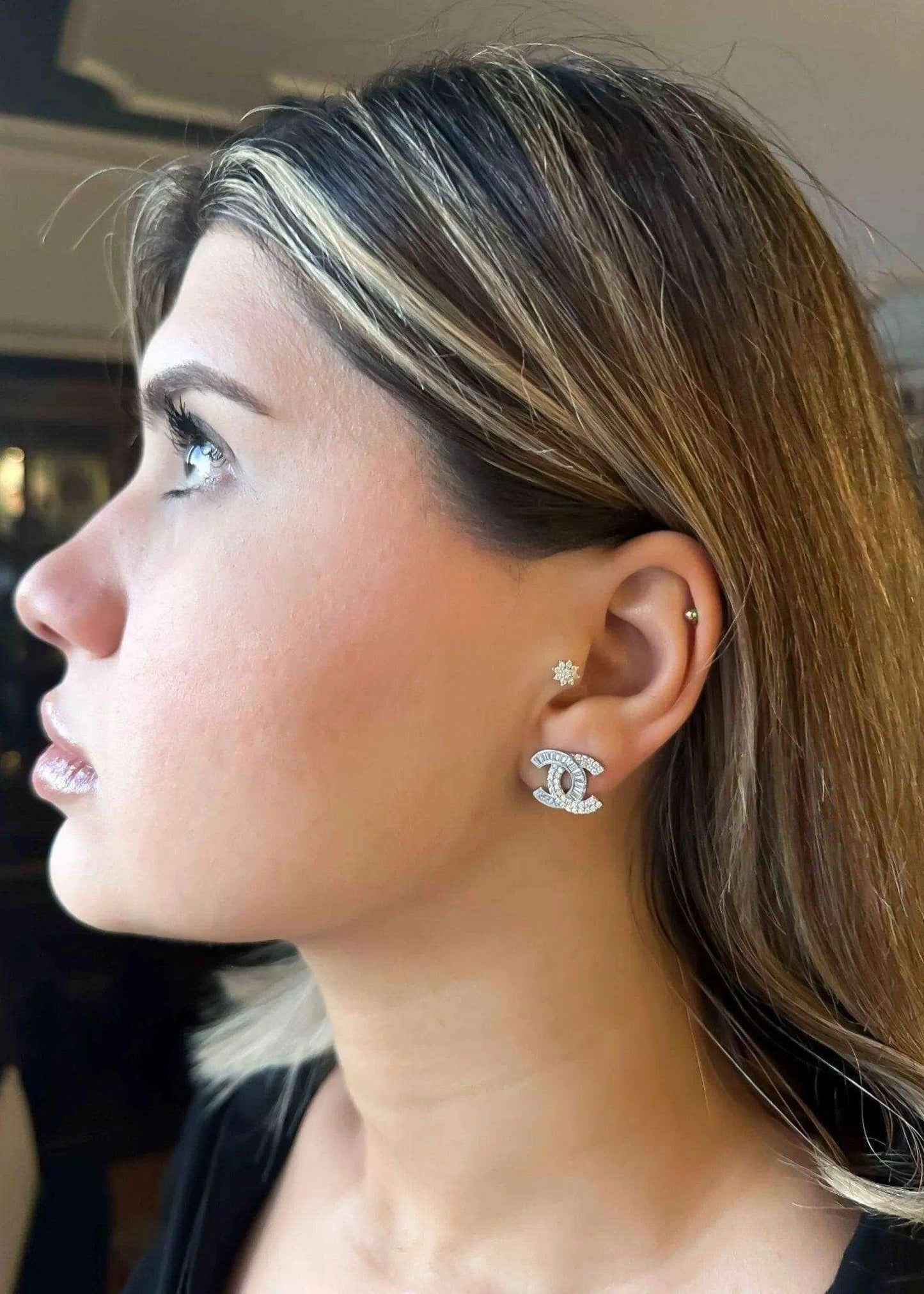 Authentic Chanel stud earrings in 925 sterling silver with white zircon baguette stones worn by woman
