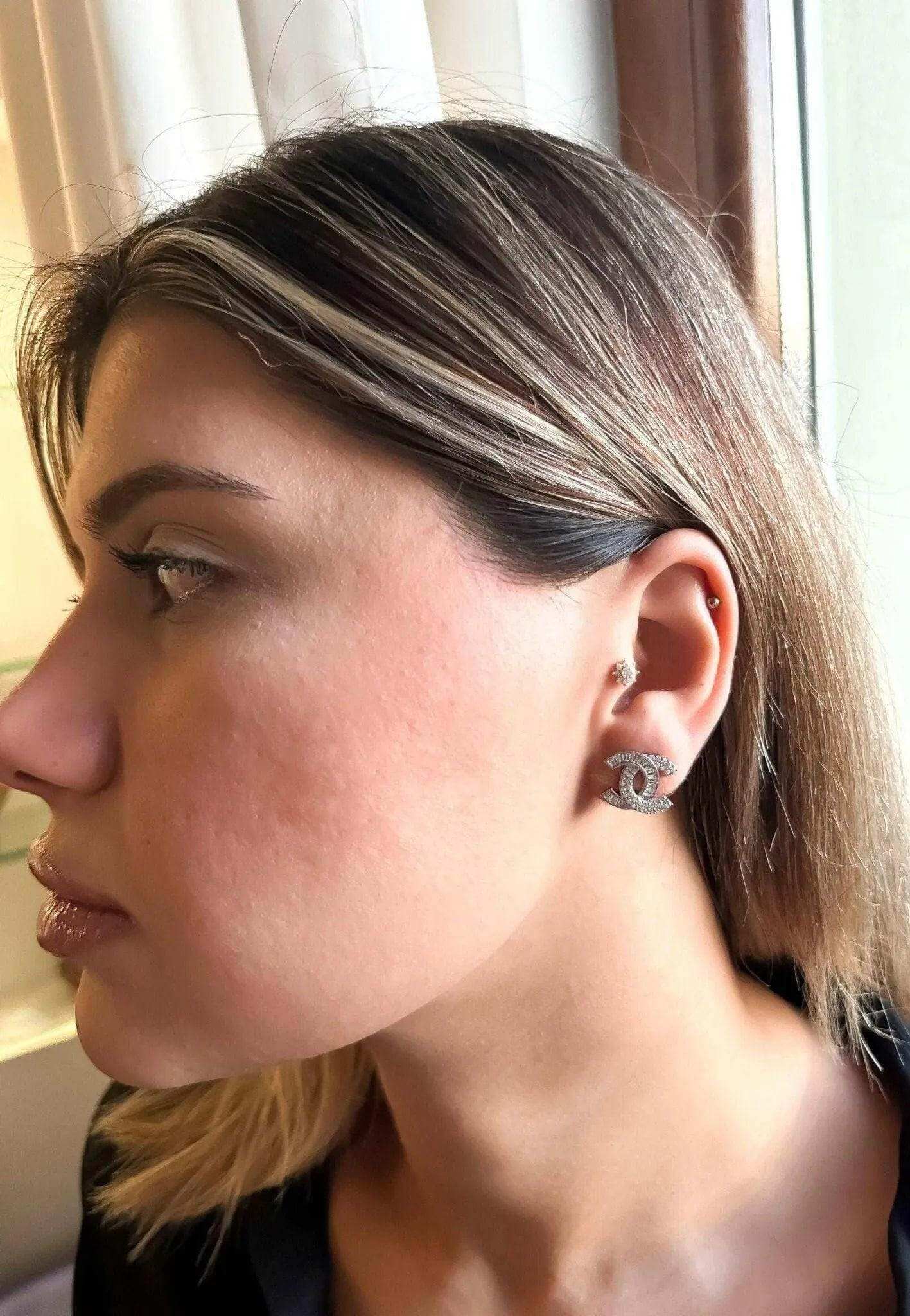 Authentic Chanel stud earrings in 925 sterling silver with baguette white zircon stones worn by woman