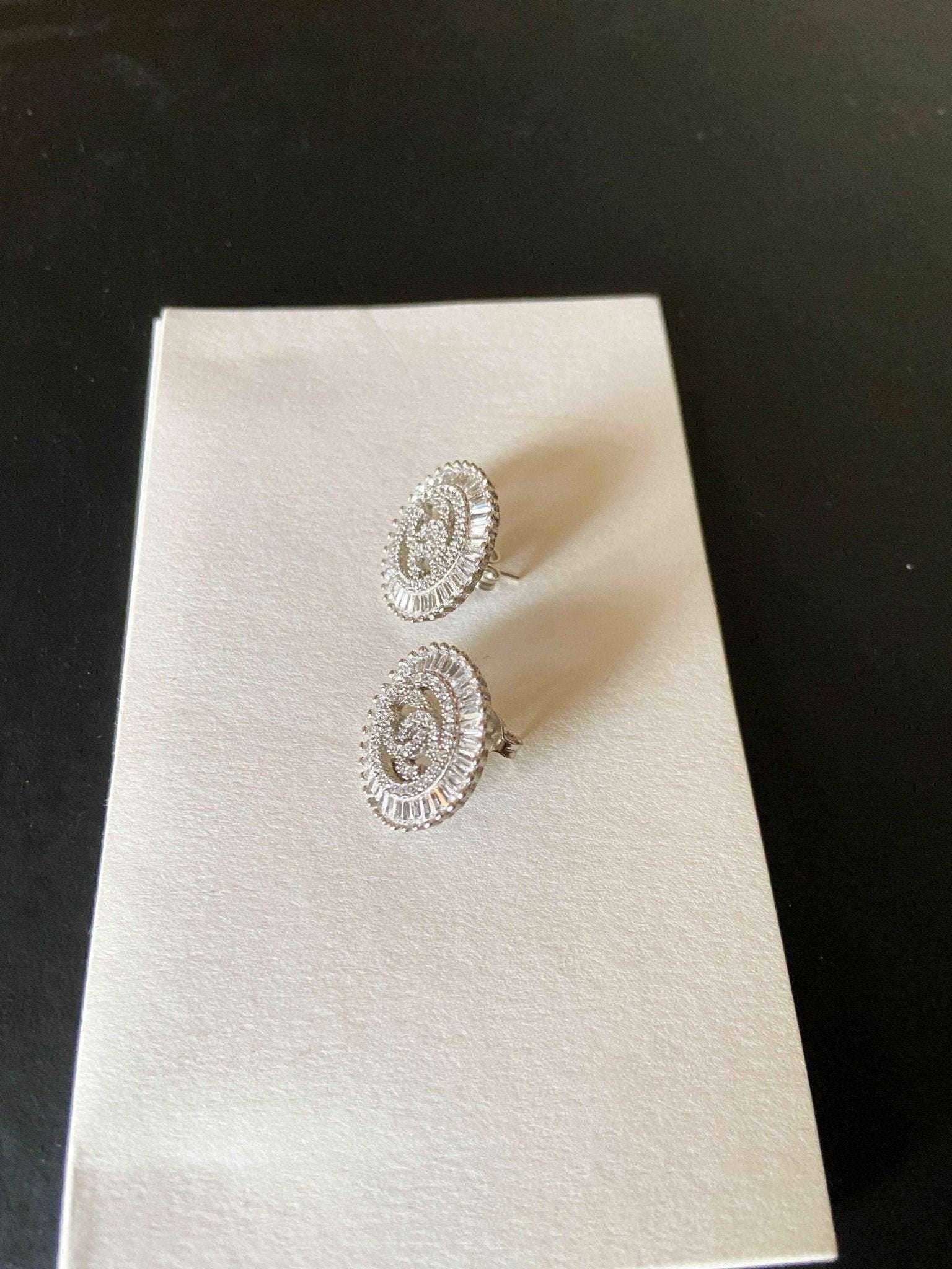 Authentic Chanel Jewelry 925 sterling silver earrings with baguette stones on white display card