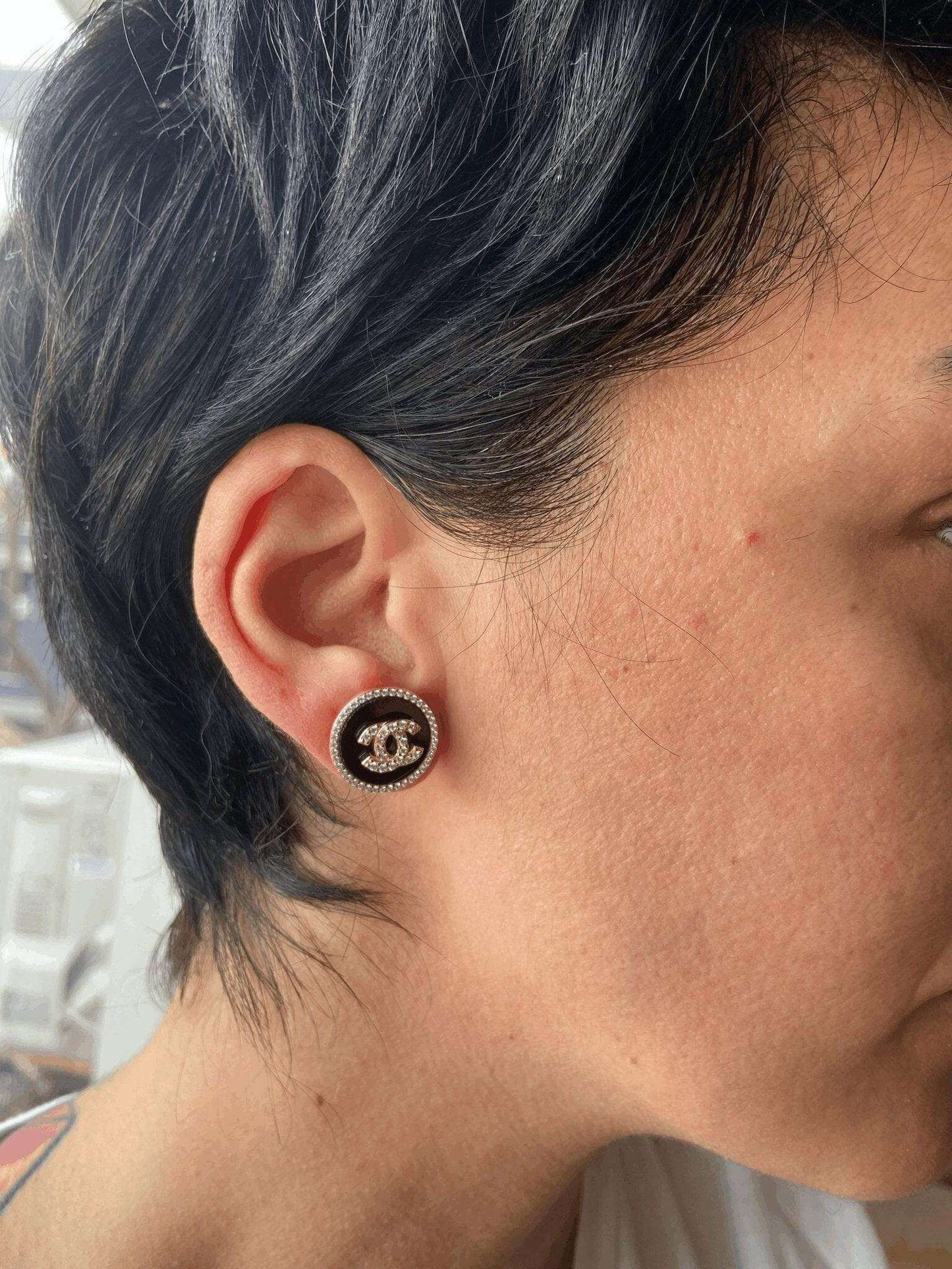 Enamel Chanel rose gold earrings with sterling silver and baguette stones worn on ear