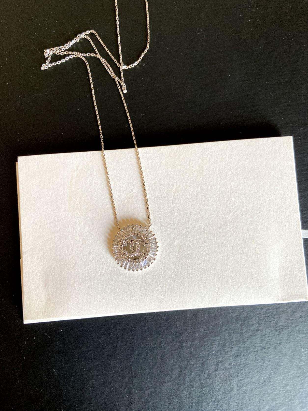 Vintage Chanel Necklace 925 sterling silver with baguette stones on chain displayed on white card