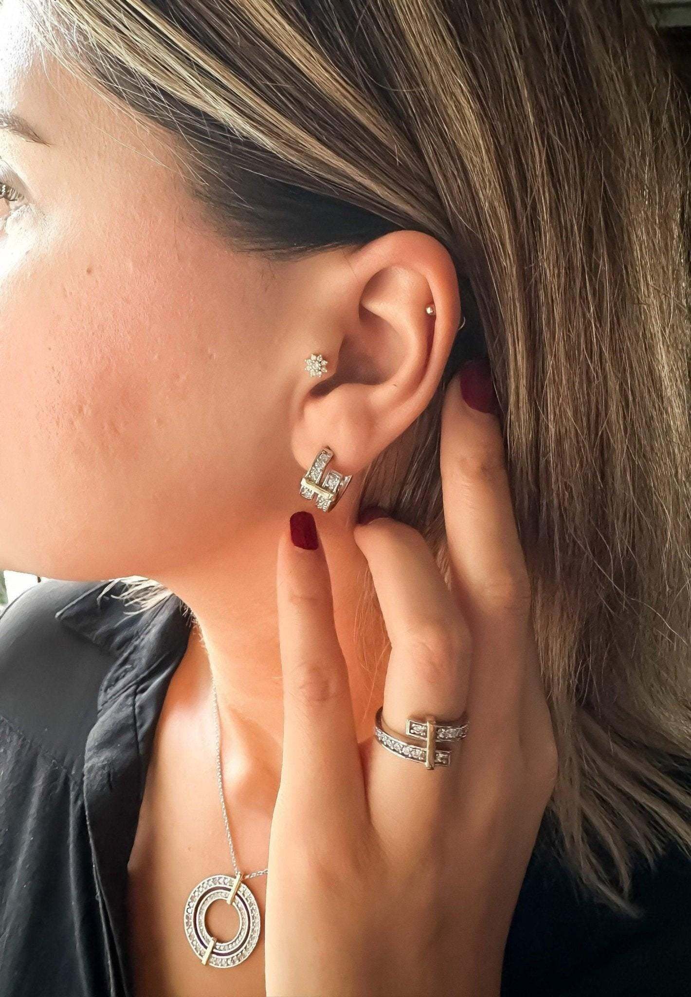 Close-up of woman wearing Tiffany&Co 925 sterling silver earrings with matching ring and necklace