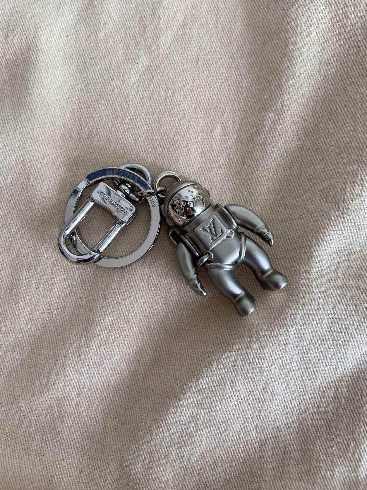 Louis Vuitton Astronaut Keychain MP2213 Silver on fabric background