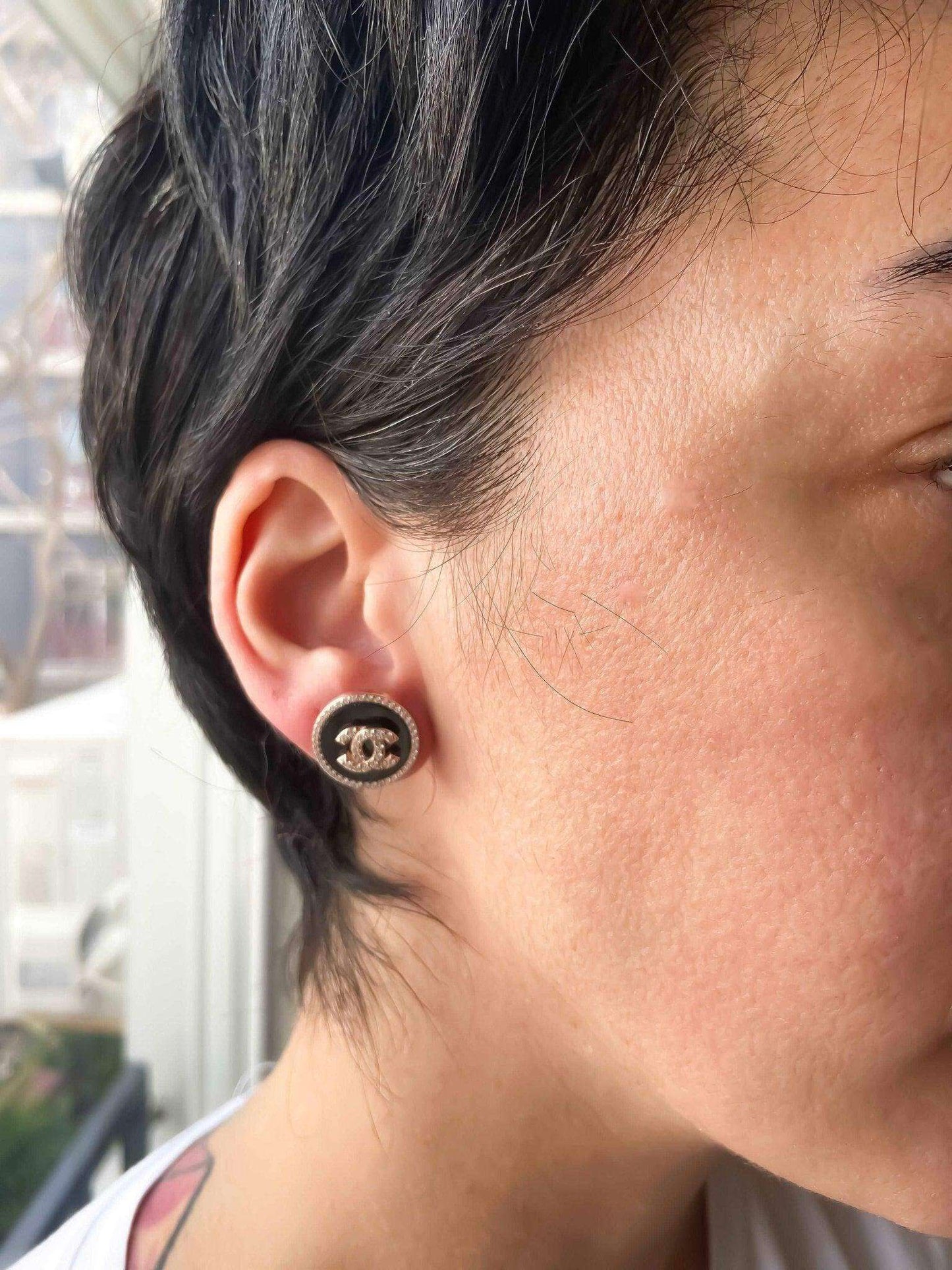 Close-up of a person wearing enamel Chanel vintage rose gold earrings with 925 sterling silver and baguette stones.