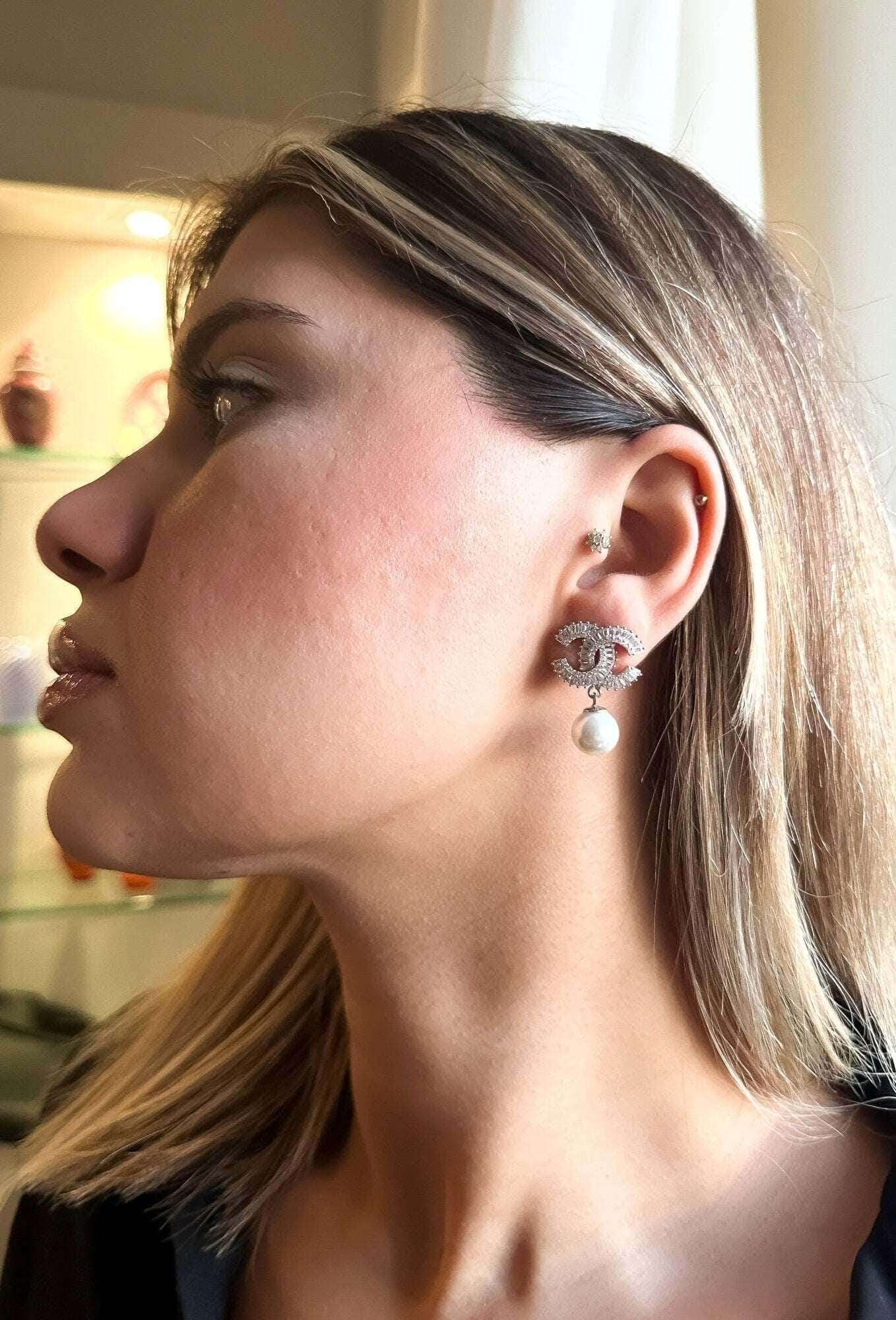 Chanel Jewelry Stud vintage pearl earrings in 925 sterling silver with white zircon baguette stones worn on woman's ear