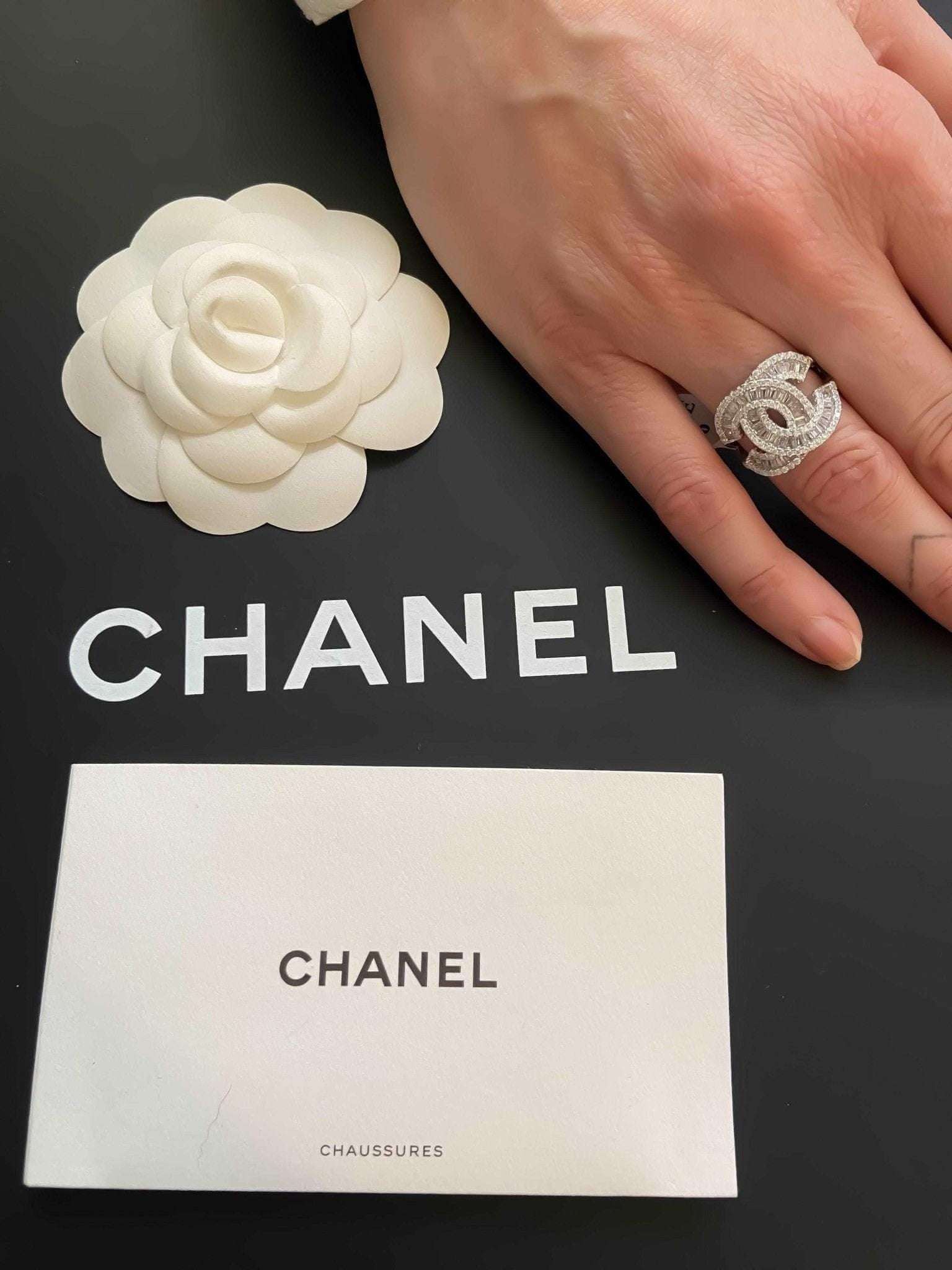 Authentic Chanel ring in 925 sterling silver with baguette white zircon stones on hand over Chanel packaging
