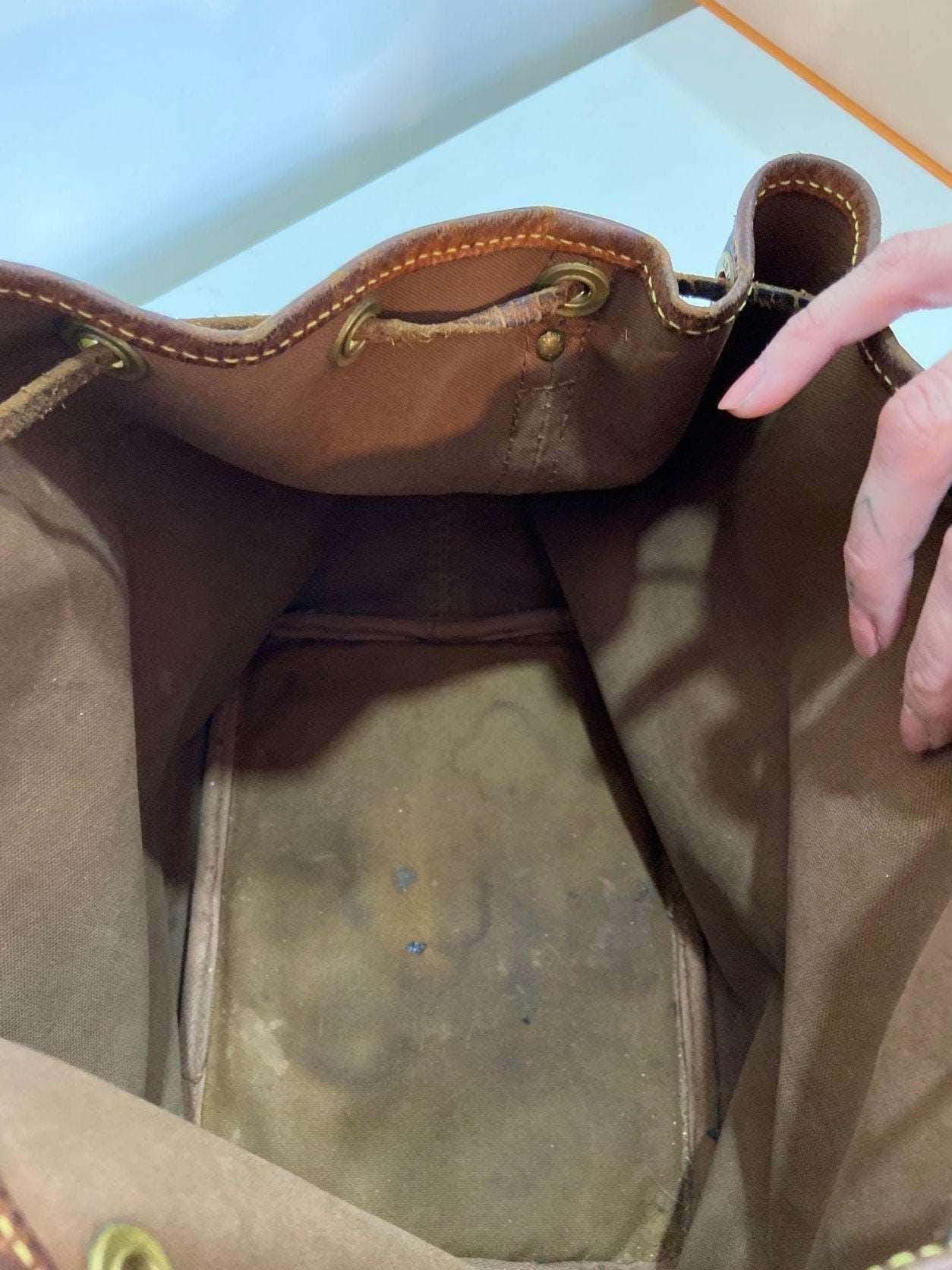 Interior view of authentic vintage Louis Vuitton Noe bag showing brown suede lining and signs of wear