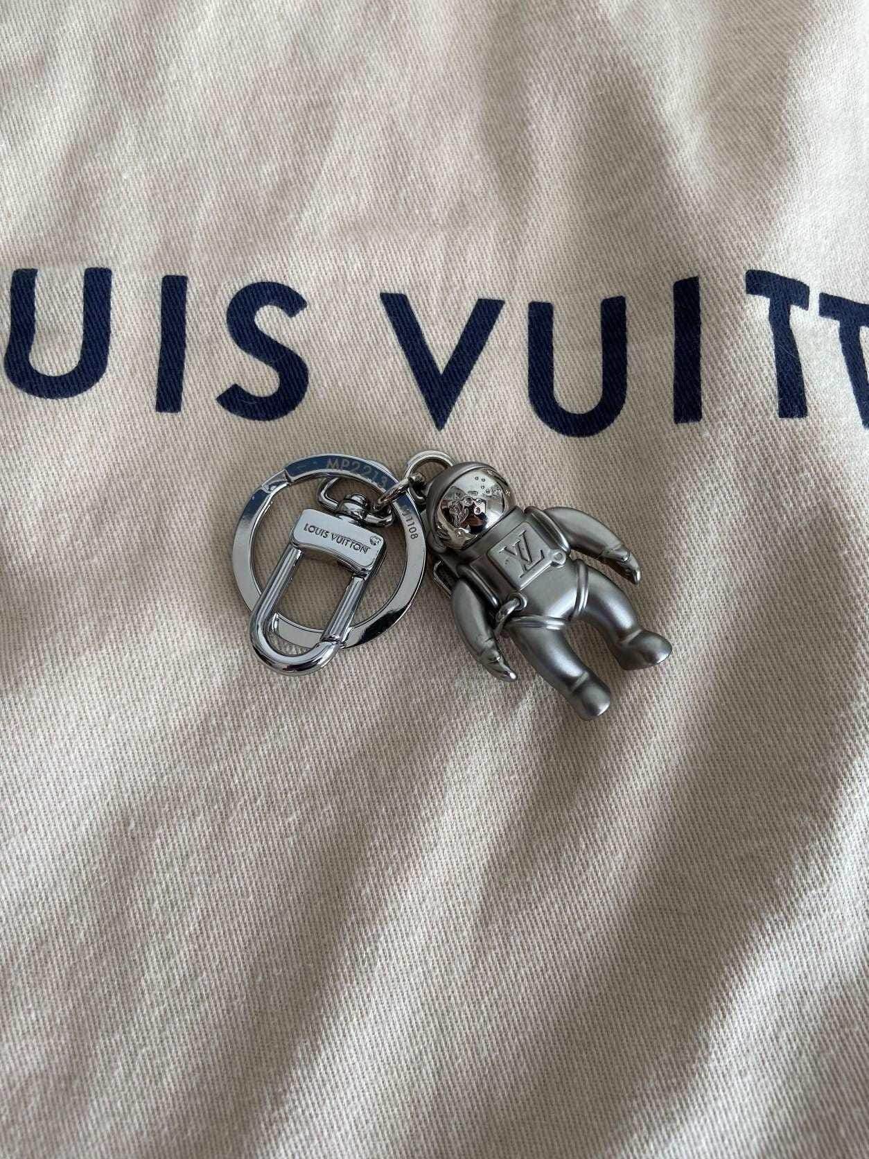 Louis Vuitton Astronaut Keychain MP2213 Silver on branded cloth background