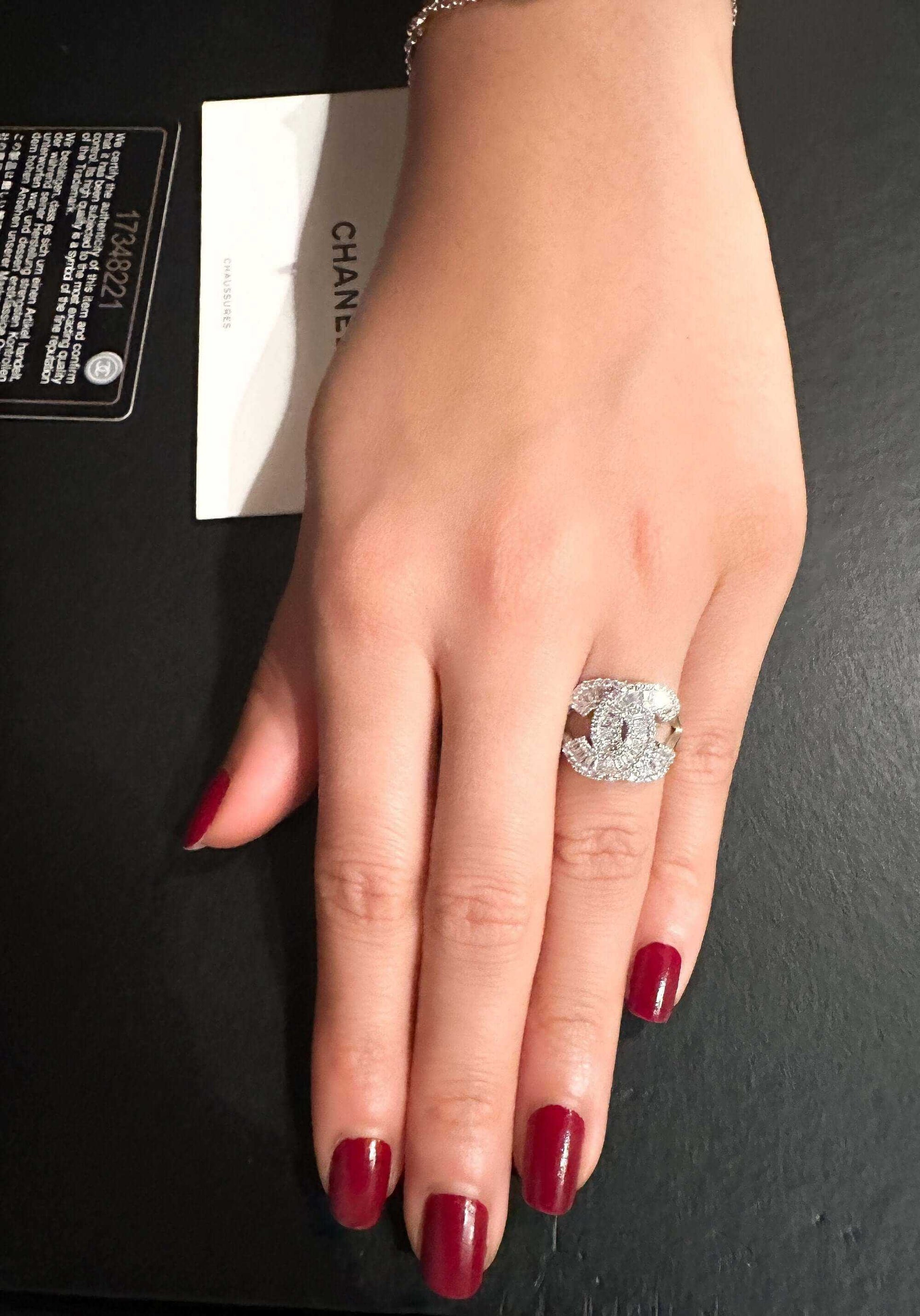 925 Sterling Silver Chanel ring with zircon stone on hand with red nail polish